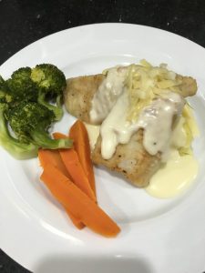 Hake with a cheesy sauce, mash and veg